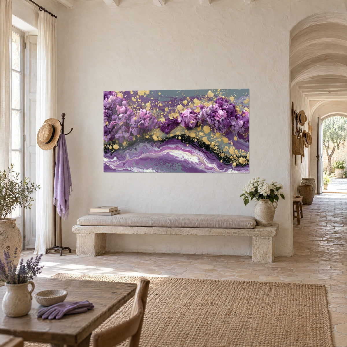 Quadro con bouquet astratto lilla e malva, pepite dorate su fondo grigio-verde, appeso sopra una panca di pietra in un casale