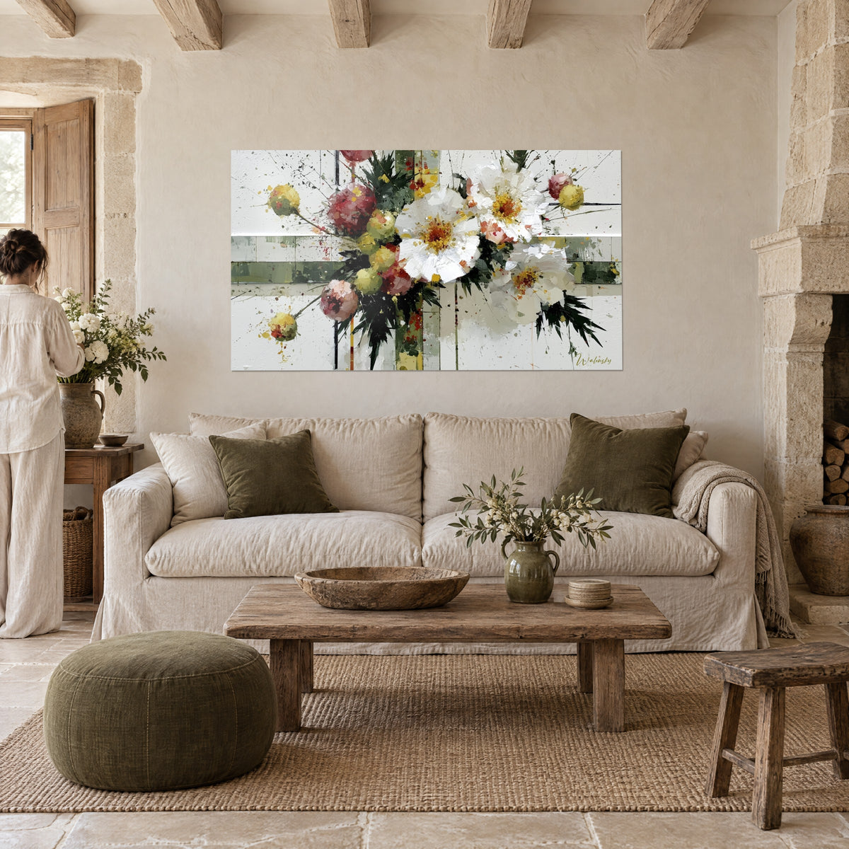 Wall art white peonies splashed with pink and gold on an ivory background, woman seen from behind, above a sofa in a bright living room
