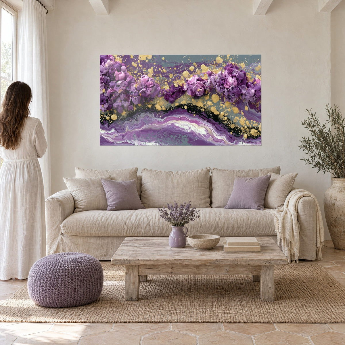 Quadro con grappoli di fiori viola e schizzi d'oro su onde marmorizzate, sopra un divano in un soggiorno luminoso