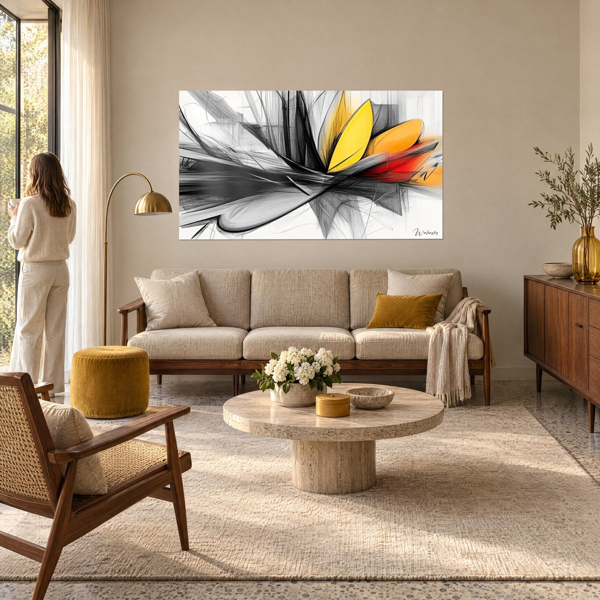 Tableau fleur abstraite aux pétales jaune vif et orange, traits de fusain noir et rouge, femme de dos au-dessus d'un canapé dans un salon lumineux