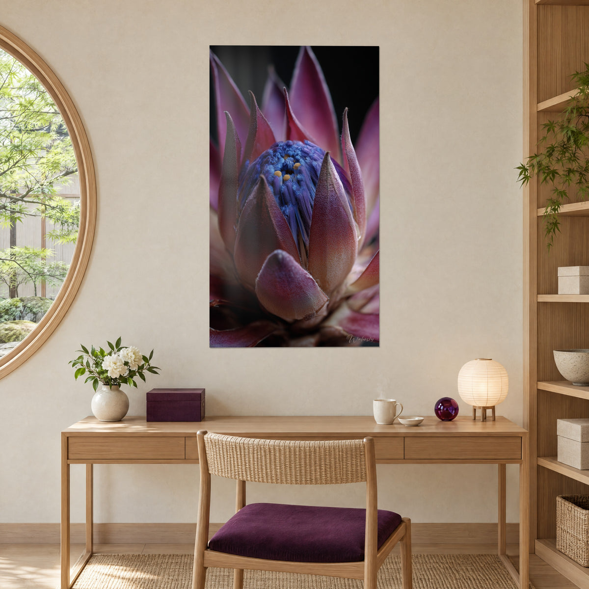 Tableau cœur floral bleu outremer entouré de pétales mauves et pourpres, accroché au-dessus d'un bureau en bois clair