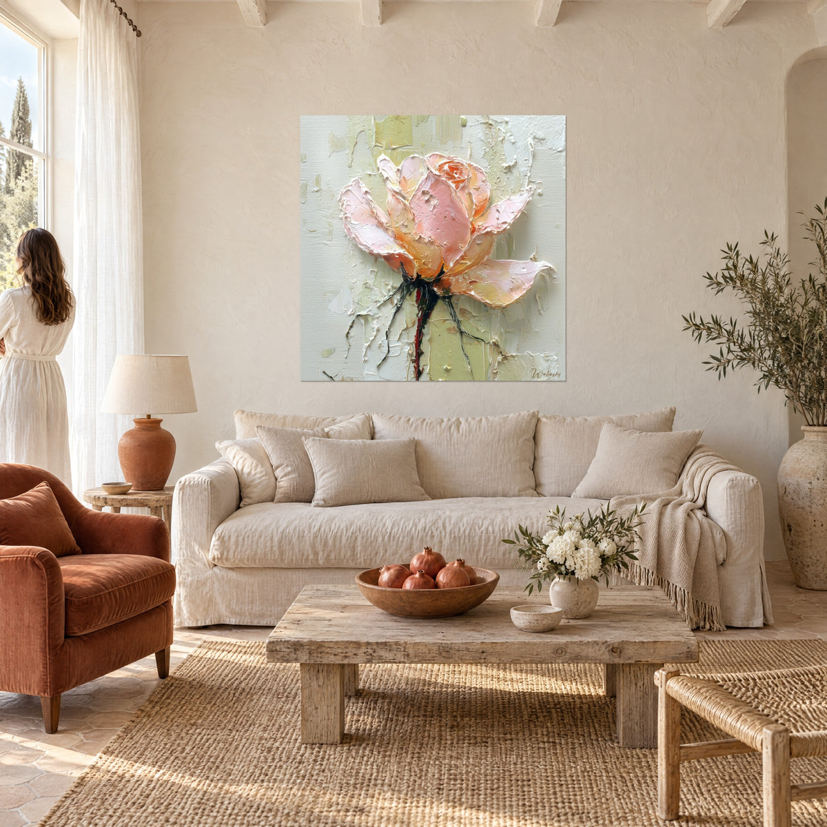 Tableau rose épanouie aux pétales rose pâle et pêche en relief, femme de dos, au-dessus d'un canapé dans un salon lumineux