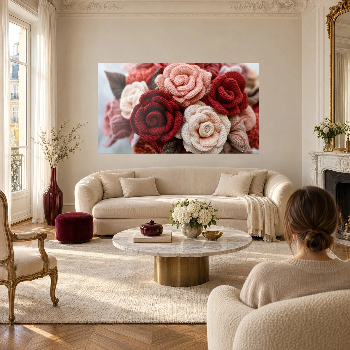 Gemälde Rosenstrauß aus Häkelarbeit, Karminrot und puderrosa, spiralförmige Blütenblätter, über einem Sofa in einem hellen Wohnzimmer