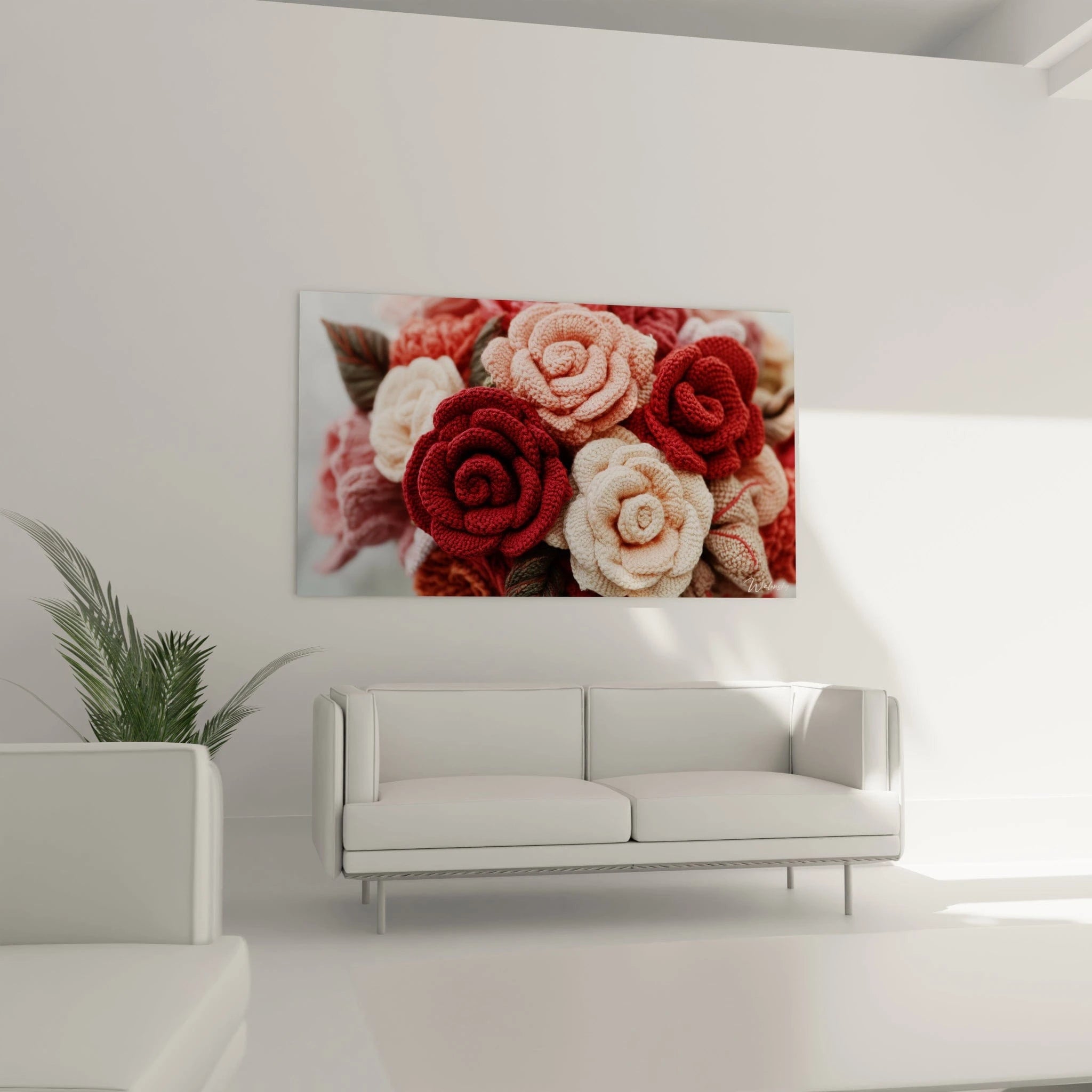 Un tableau floral en crochet montrant un arrangement dense de roses artisanales aux tons rouge vif, rose saumon et blanc cassé, créant un effet de profondeur par la superposition des pétales texturés et la variation des tailles.
