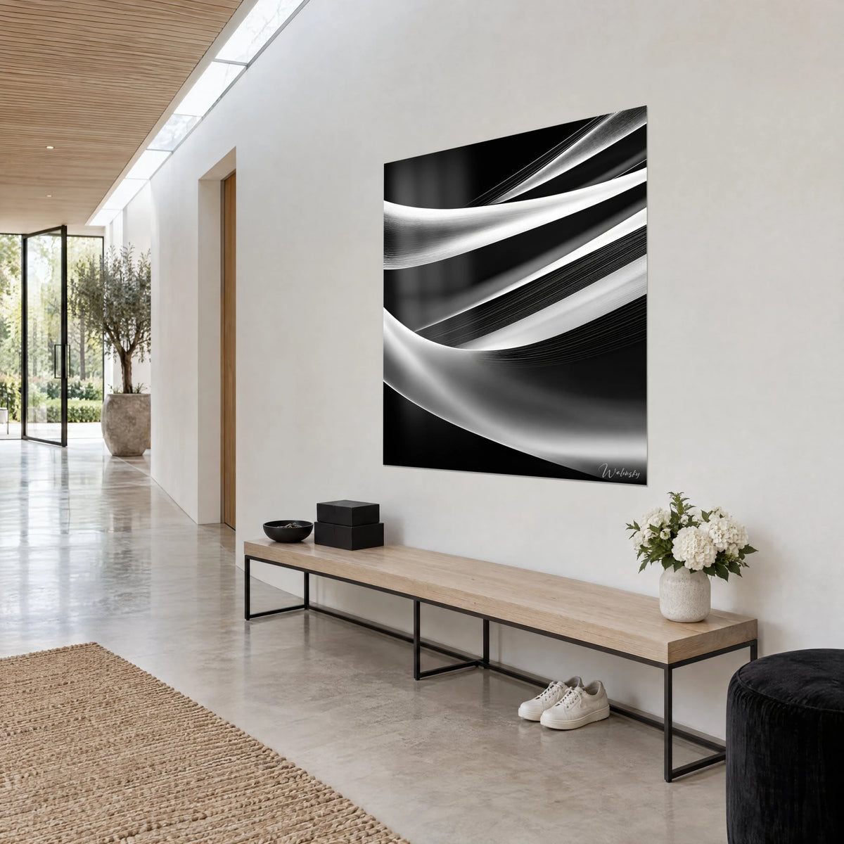 Wall art with abstract pearly white veils slipping out of black shadow, hung at a three-quarter angle above a light wood bench
