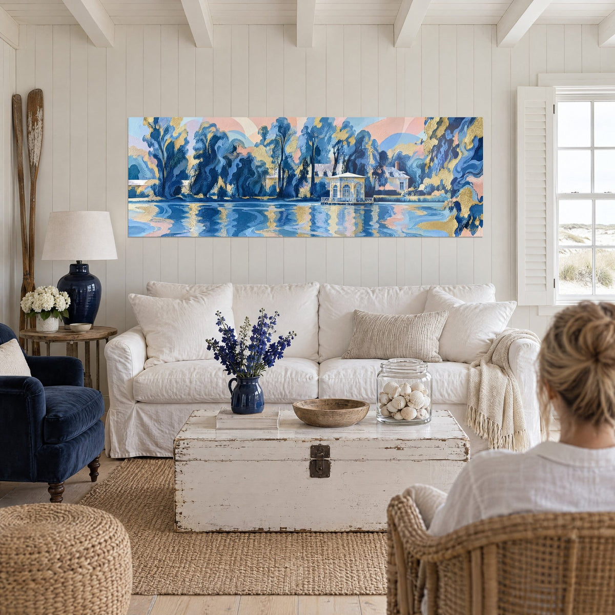 Quadro padiglione dorato sul laghetto, alberi blu cobalto e riflessi rosa tenue, due persone di spalle sopra un divano in un soggiorno luminoso