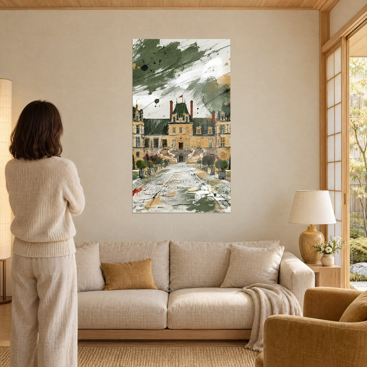 Schilderij kasteel van Fontainebleau in kaki- en beigekleurige lavis, geplaveid pad en bomen in potten, boven een bank in een lichte woonkamer