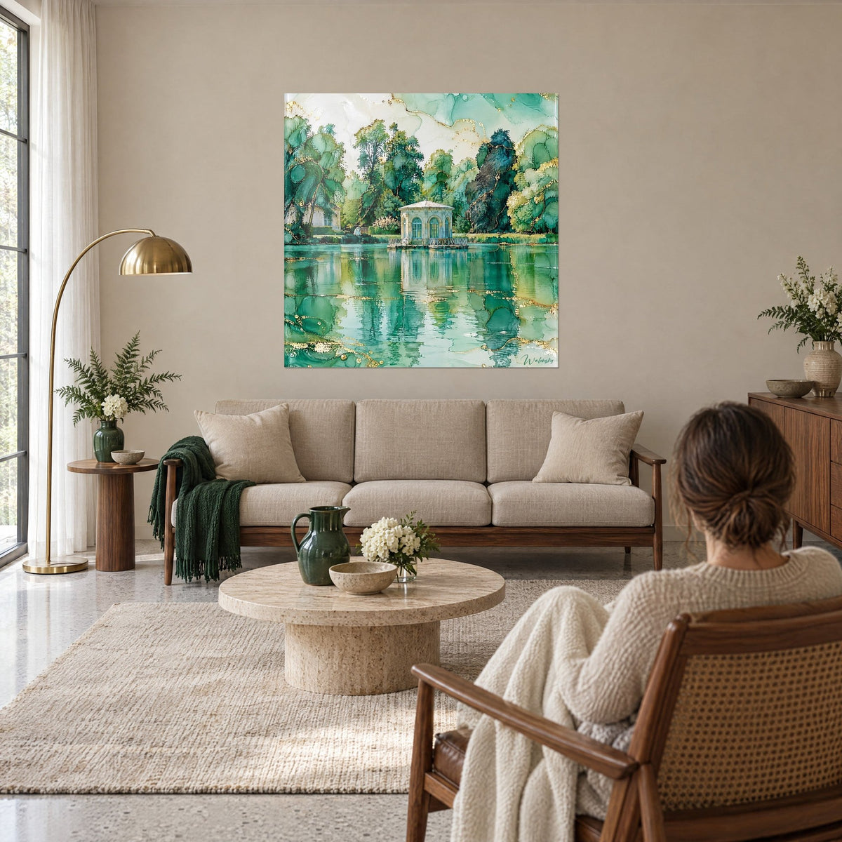 Quadro Chiosco bianco su uno stagno verde smeraldo, riflessi dorati, donna di spalle, sopra un divano in un soggiorno luminoso