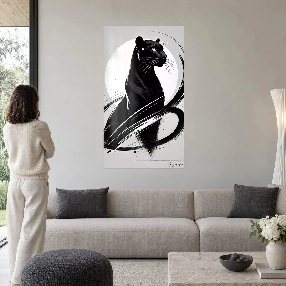 Wall art black panther on white moon, grey and black brushstrokes, woman seen from behind, above a sofa in a bright living room