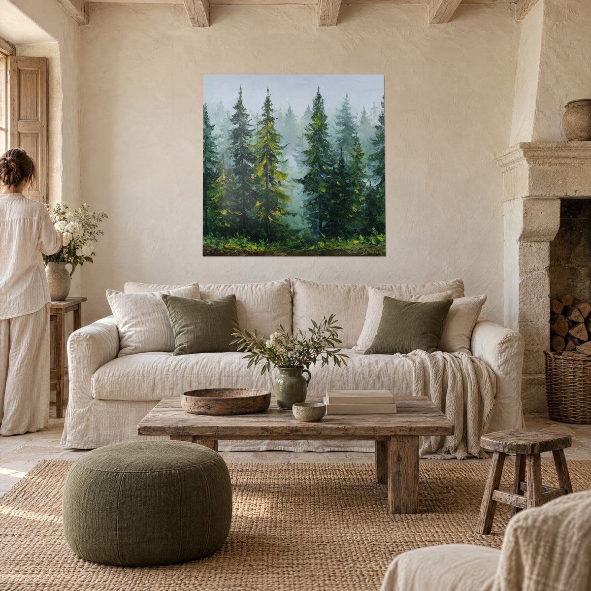 Tableau sapins élancés dans la brume, verts profonds et touches dorées, deux personnes de dos au-dessus d'un canapé dans un salon lumineux