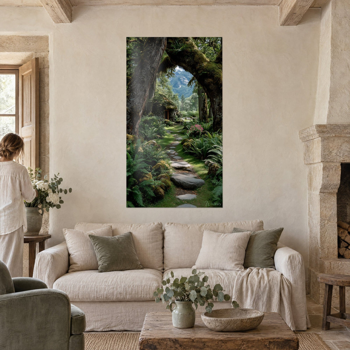Quadro sentiero di pietre piatte sotto un arco di alberi ricoperti di muschio, felci verdi, baita di pietra, donna di spalle, sopra un divano in un soggiorno luminoso