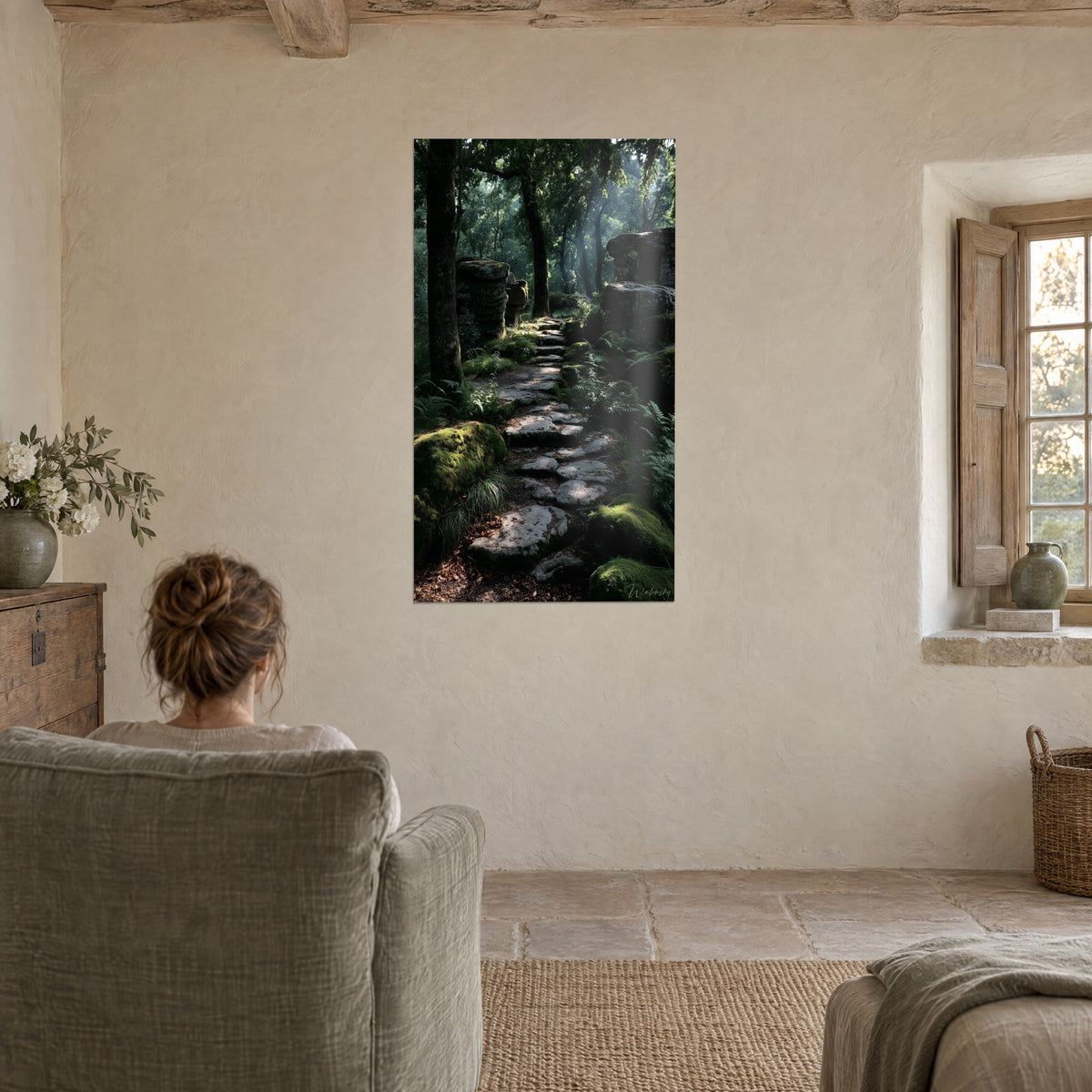 Cuadro sendero de cuento de piedras bajo el dosel, verde profundo y brillo dorado, persona de espaldas en un sillón, casa de campo de piedra