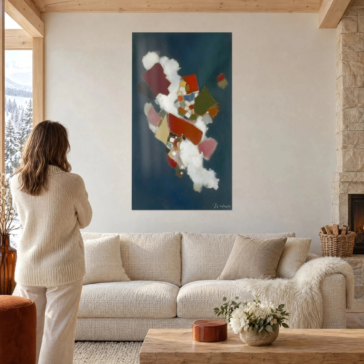 Wall art geometric shape collage in burgundy and olive green on a midnight blue background, woman seen from behind, above a sofa in a bright living room