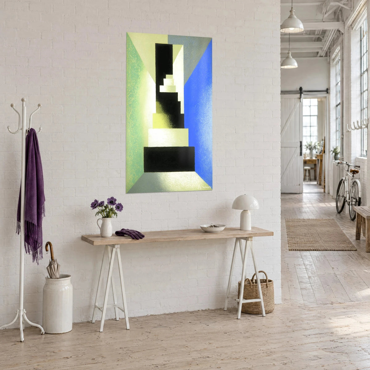 Tableau perspective géométrique en gradins ivoire, jaune pâle et noir, bleu vif à droite, sur un mur blanc d'un loft
