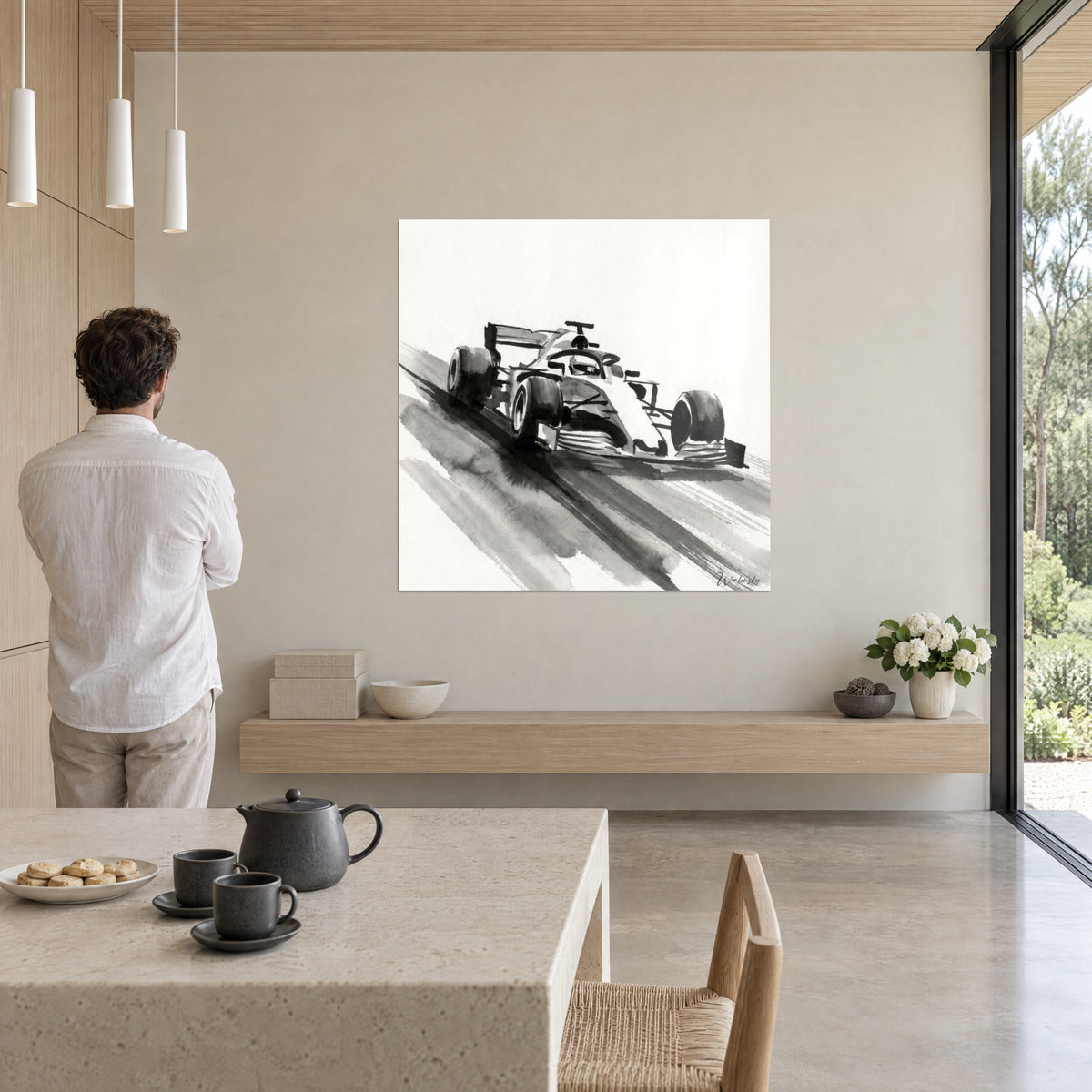 Wall art of a race car with an ink-washed black rear wing on off-white background, man seen from behind, cream wall, large picture window