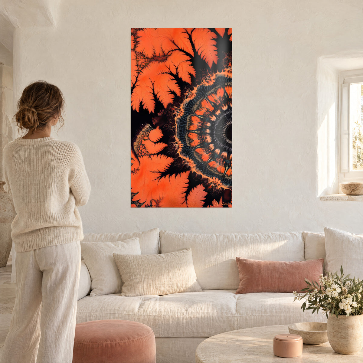 Oranje fractal schilderij met kantige varenbladeren rond een zwarte rozet, boven een bank in een lichte woonkamer