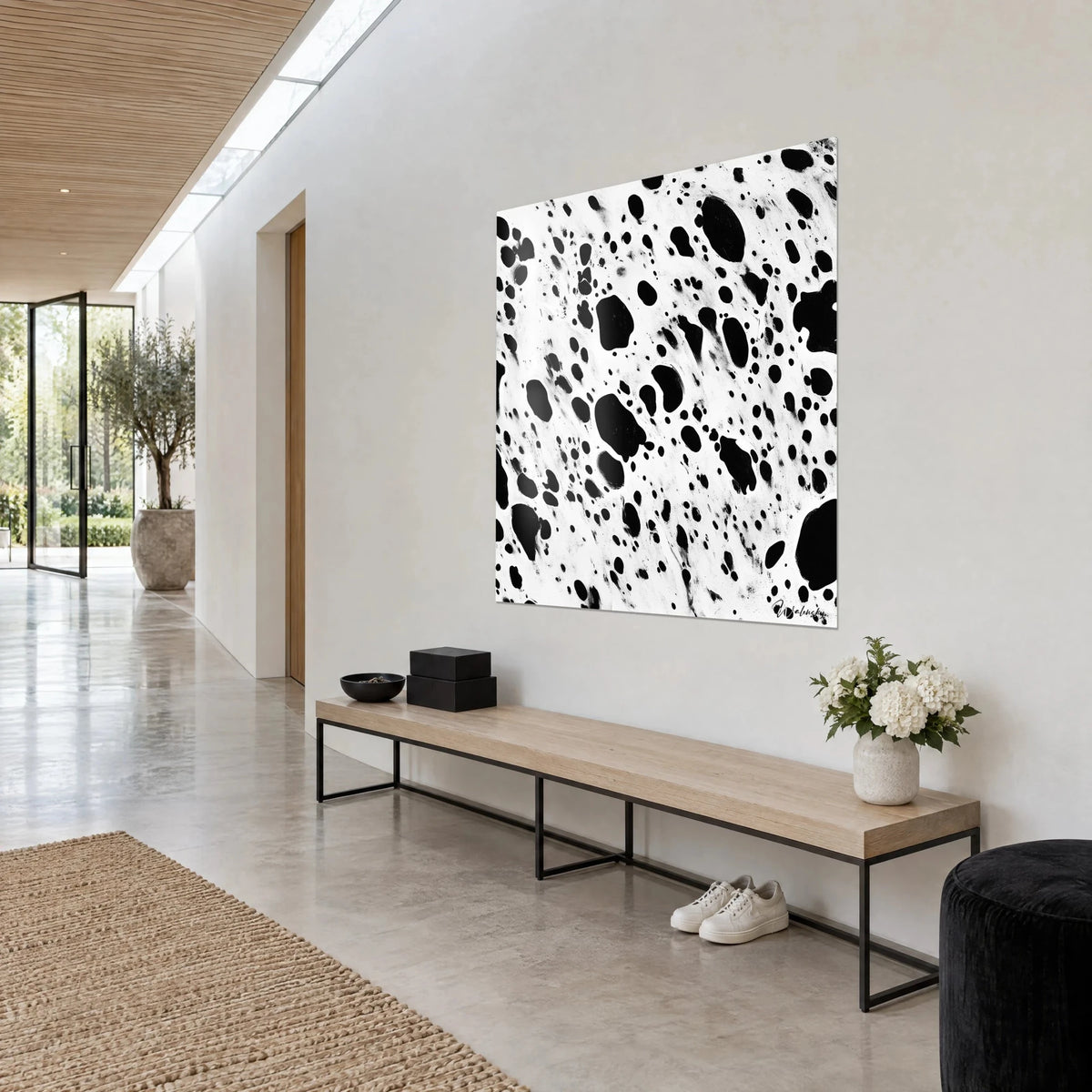 Tableau gouttes d'encre noires et traînées blanches en pointillé, mur clair, banc de bois et fleurs blanches en entrée