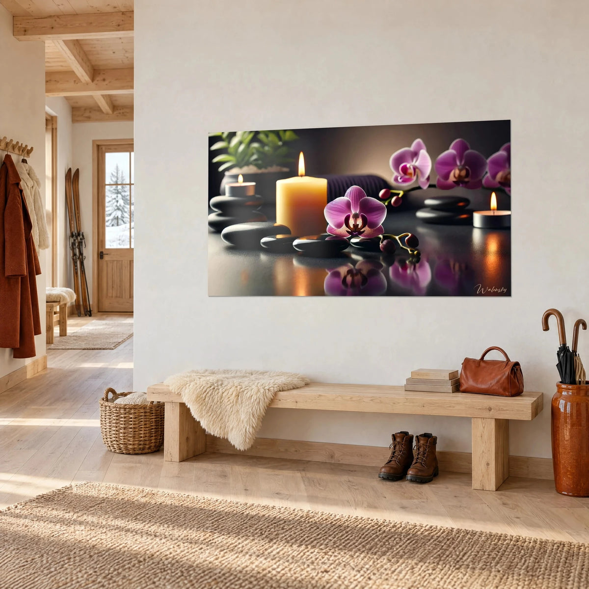 Tableau bougie ambrée flanquée d'une fleur violette et de pierres noires luisantes, sur un mur blanc de chalet