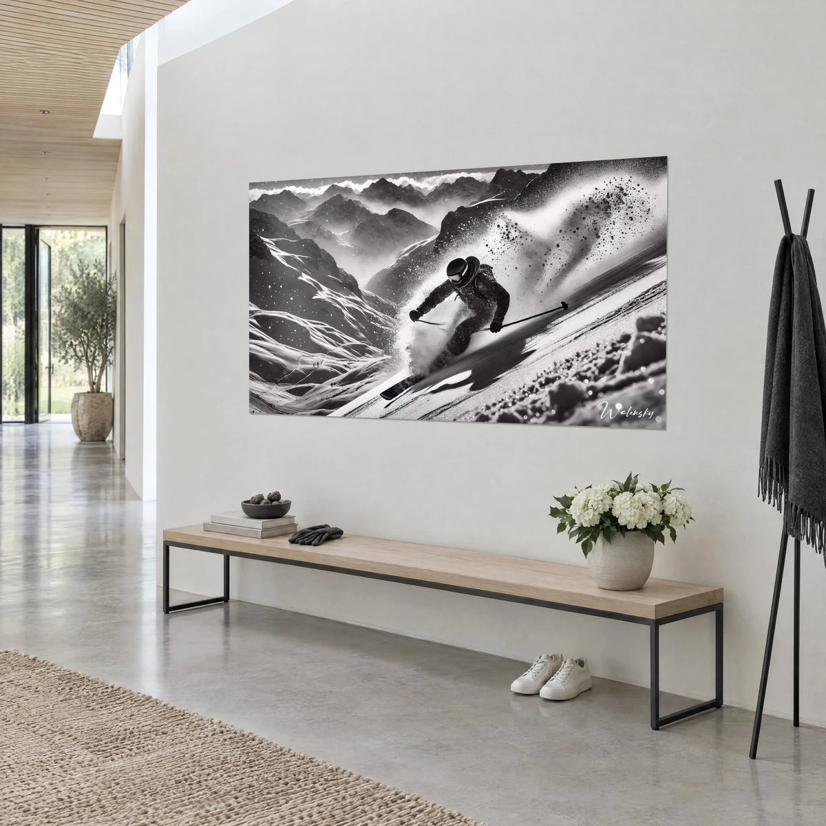 Wall art of an off-piste descent in black and white, dazzling snow and dark silhouette, on a cream wall beside a light wood bench