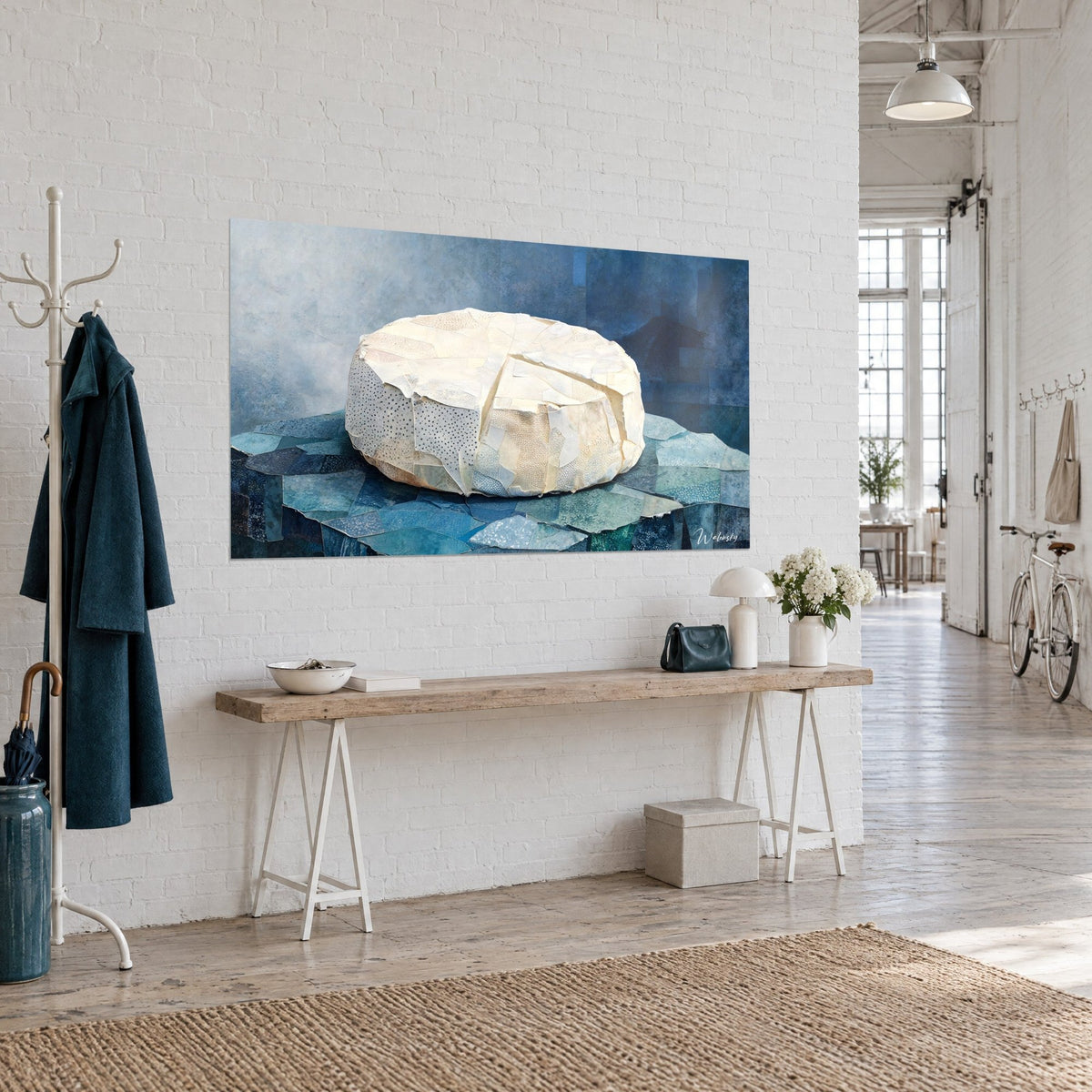Tableau camembert entamé en papiers collés crème, part découpée, fond bleu nuit et brume grise, loft aux murs de briques blanches