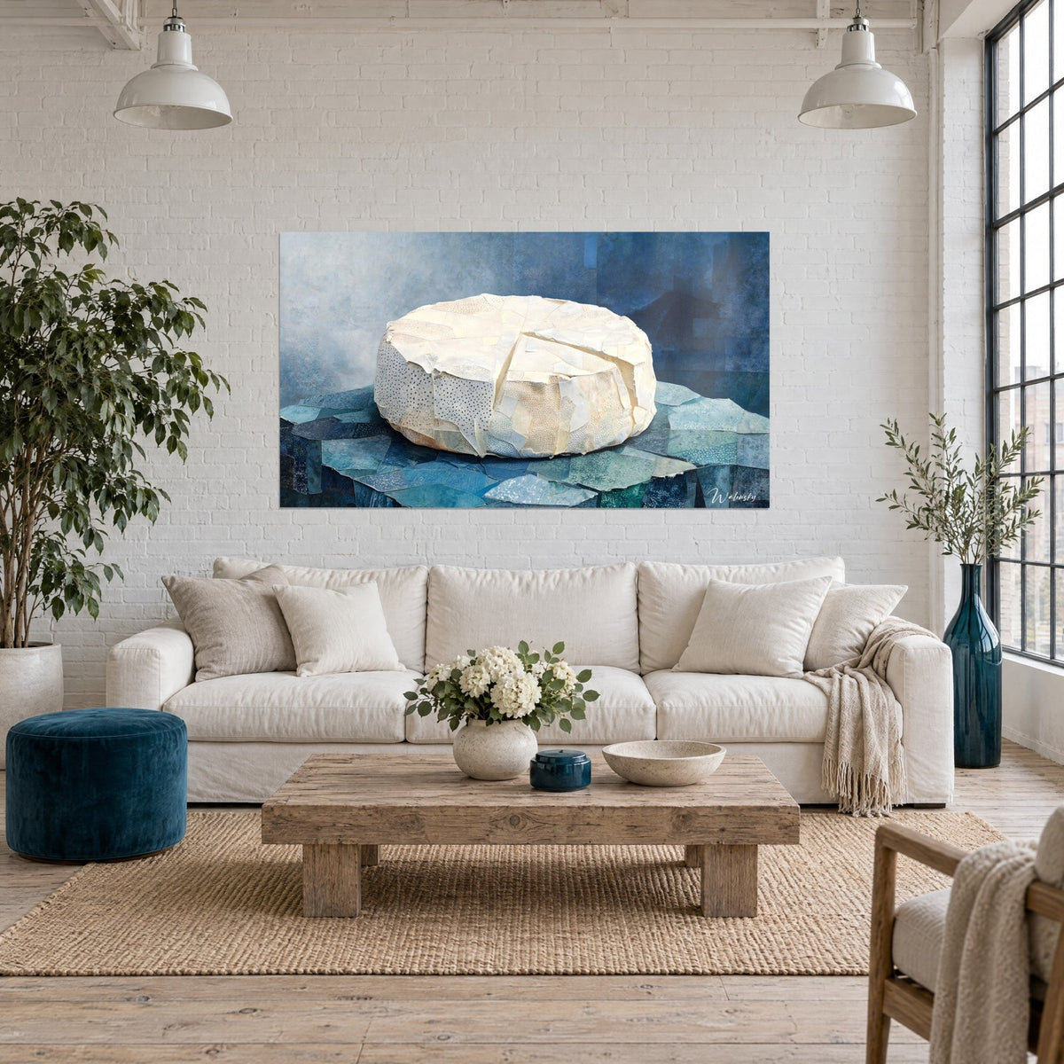 Tableau meule de fromage ivoire posée sur des éclats de papier bleus et turquoise, mosaïque, au-dessus d'un canapé dans un salon lumineux