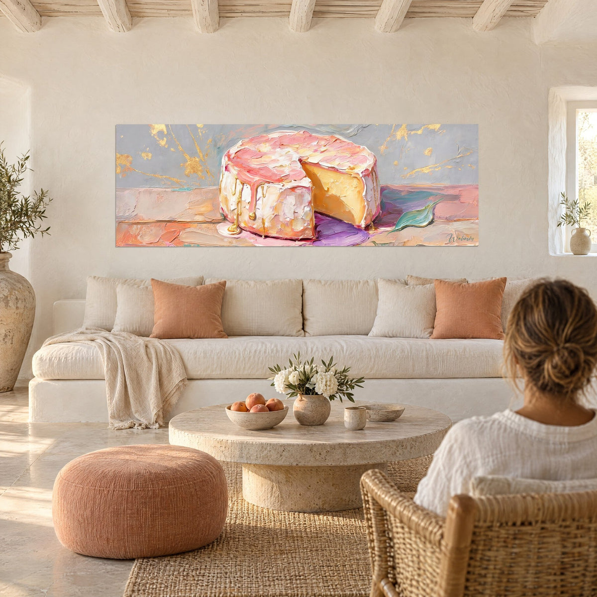 Cuadro camembert en rosa y oro, goterones perlados sobre fondo gris, encima de un sofá en un salón luminoso