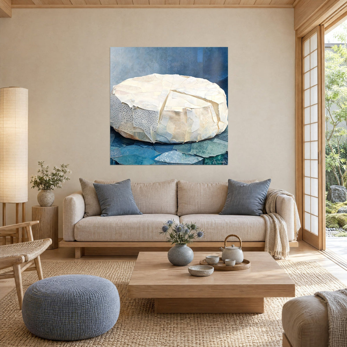 Tableau meule de fromage crémeuse en collage ivoire sur fond bleu ardoise, croûte pointillée, au-dessus d'un canapé dans un salon lumineux