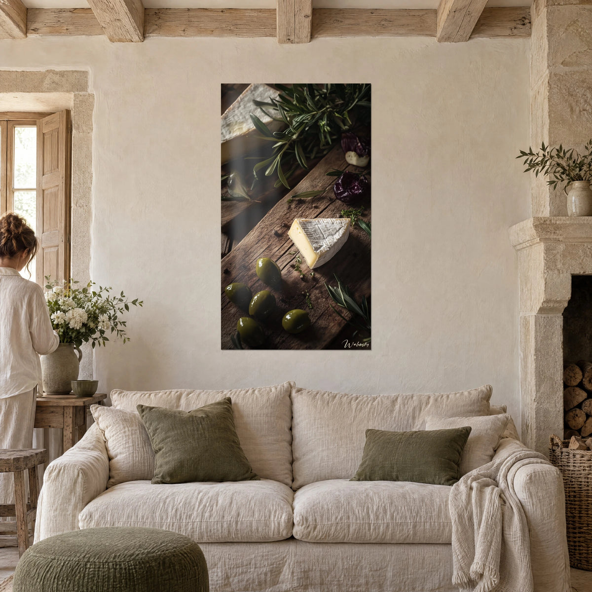 Quadro camembert cremoso su tagliere di rovere, olive verdi e rosmarino, sopra un divano in un soggiorno luminoso