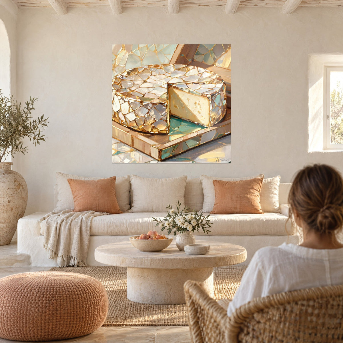 Cuadro rueda de queso en vidriera dorada y nacarada, corte crema, tabla ocre, mujer de espaldas, sobre un sofá en un salón luminoso