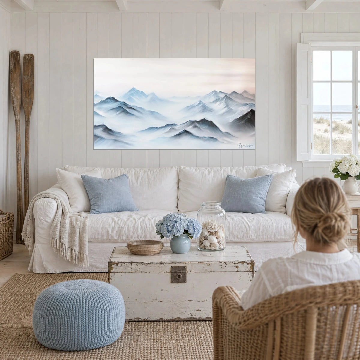 Tableau chaîne de montagnes brumeuse bleu glacier et blanc, ciel rosé, au-dessus d'un canapé dans un salon lumineux