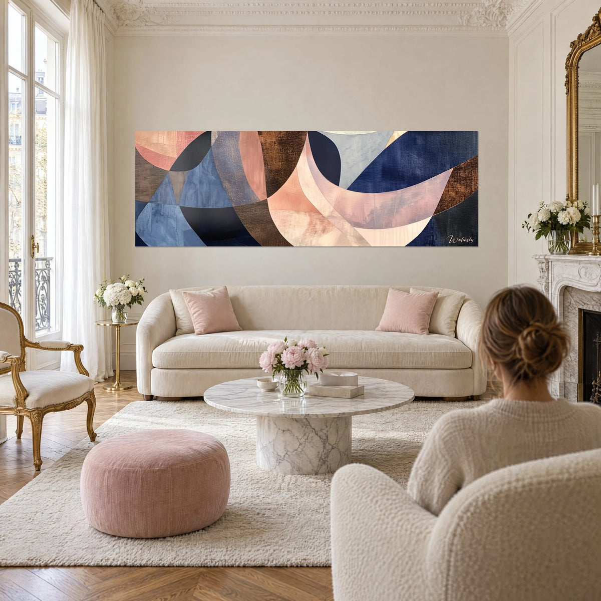 Tableau arcs géométriques abstraits bleu nuit et rose poudré, bandes cuivrées, au-dessus d'un canapé dans un salon lumineux