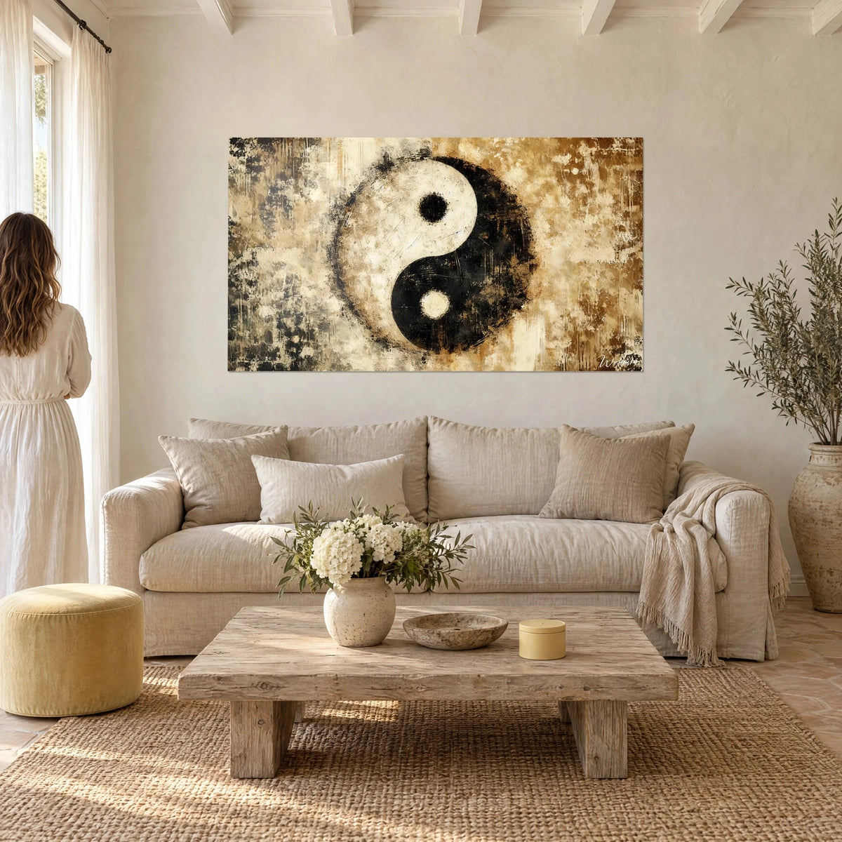 Wall art black and ivory yin yang symbol, painted relief on sepia background, woman seen from behind, above a sofa in a bright living room