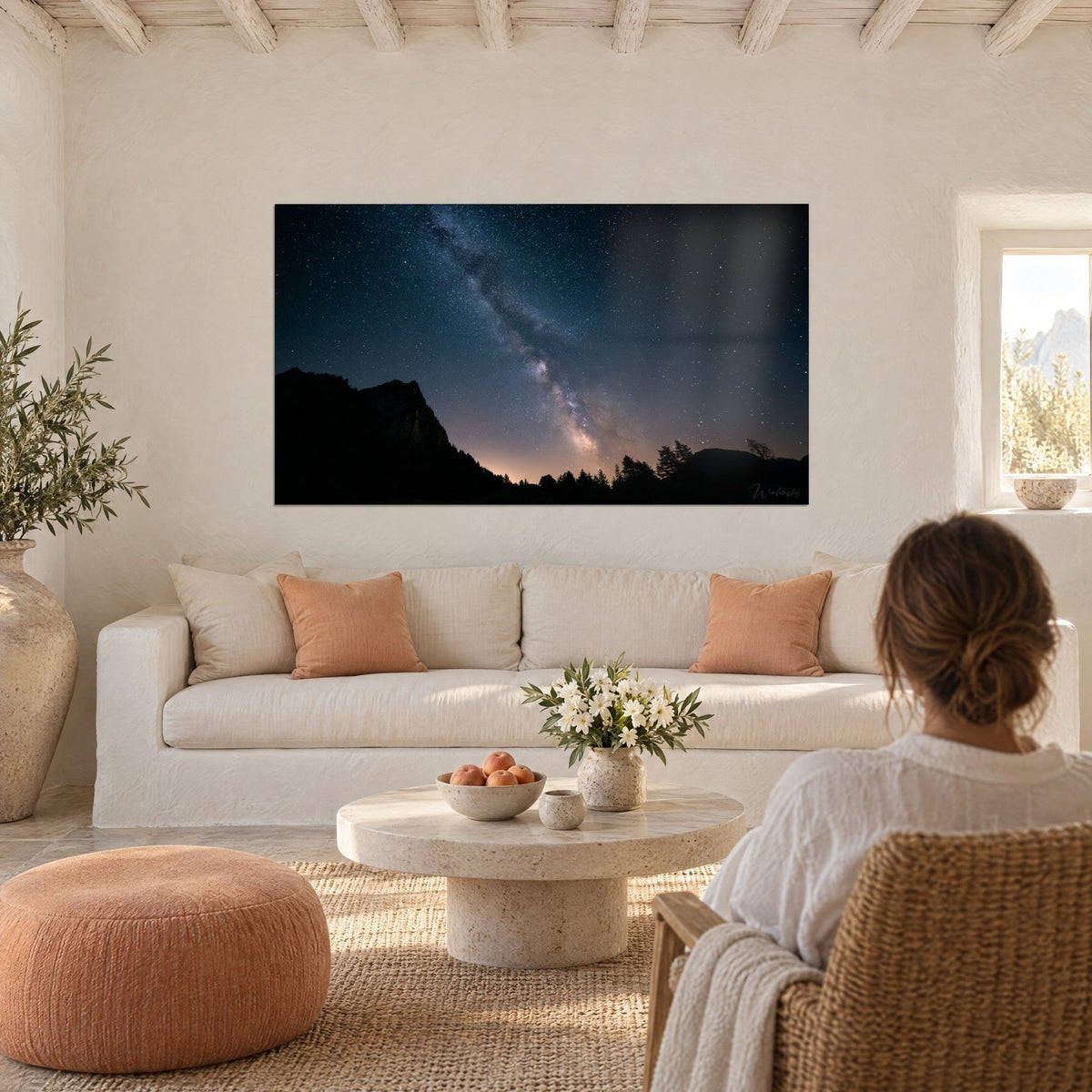 Tableau Voie Lactée laiteuse sur ciel bleu nuit, crête noire en silhouette, au-dessus d'un canapé dans un salon lumineux