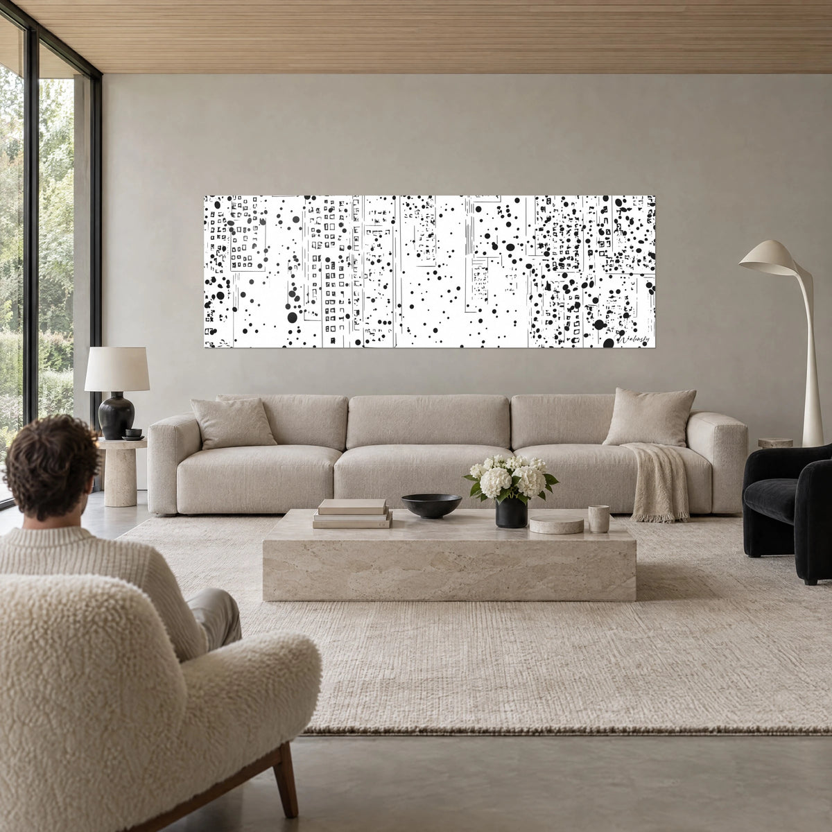 Gemälde Galaxie minimalistisch aus schwarzen Tupfen auf weißen Türmen, Person von hinten, über einem Sofa in einem hellen Wohnzimmer