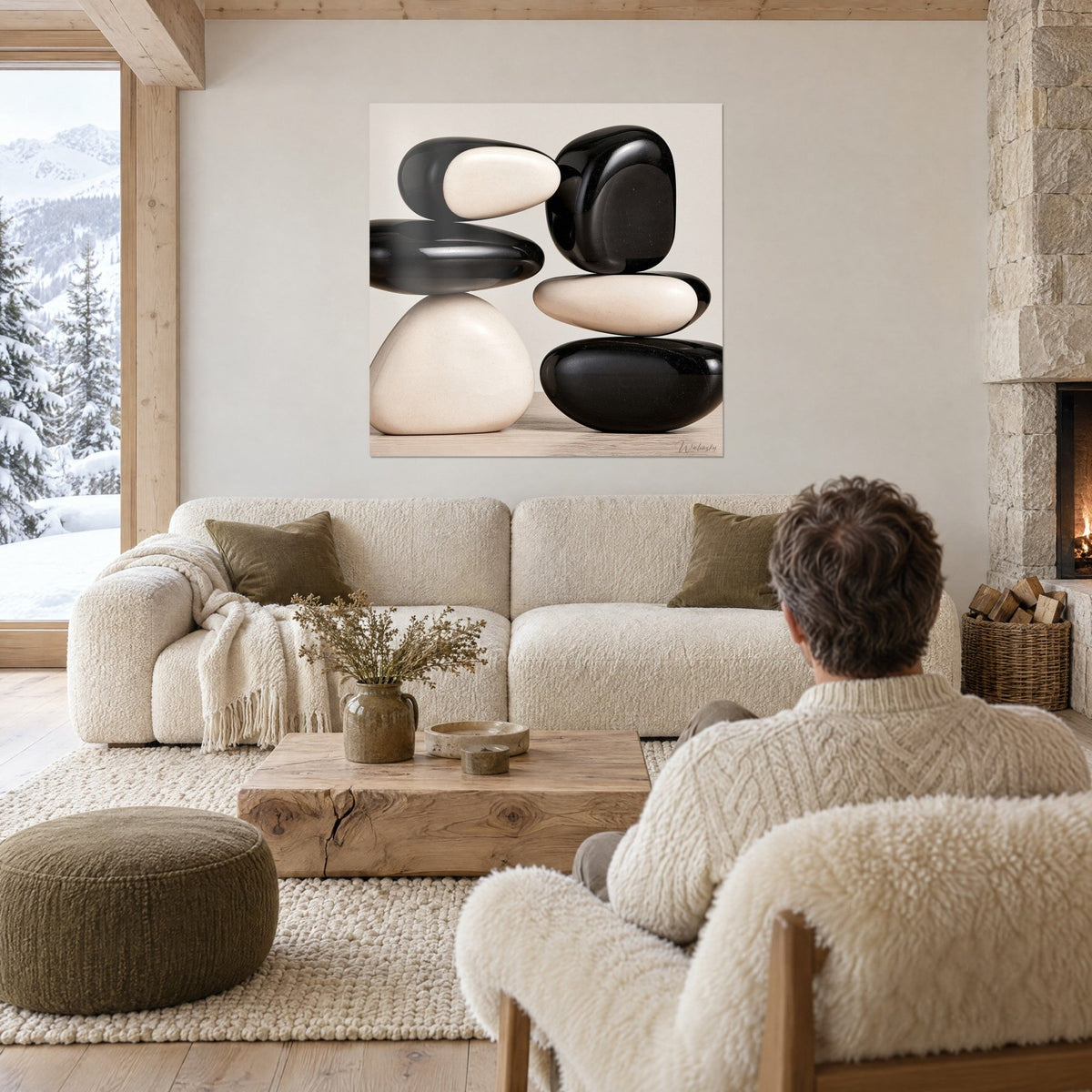 Wall art of black and ivory pebbles balanced, glossy reflections, above a sofa in a bright living room