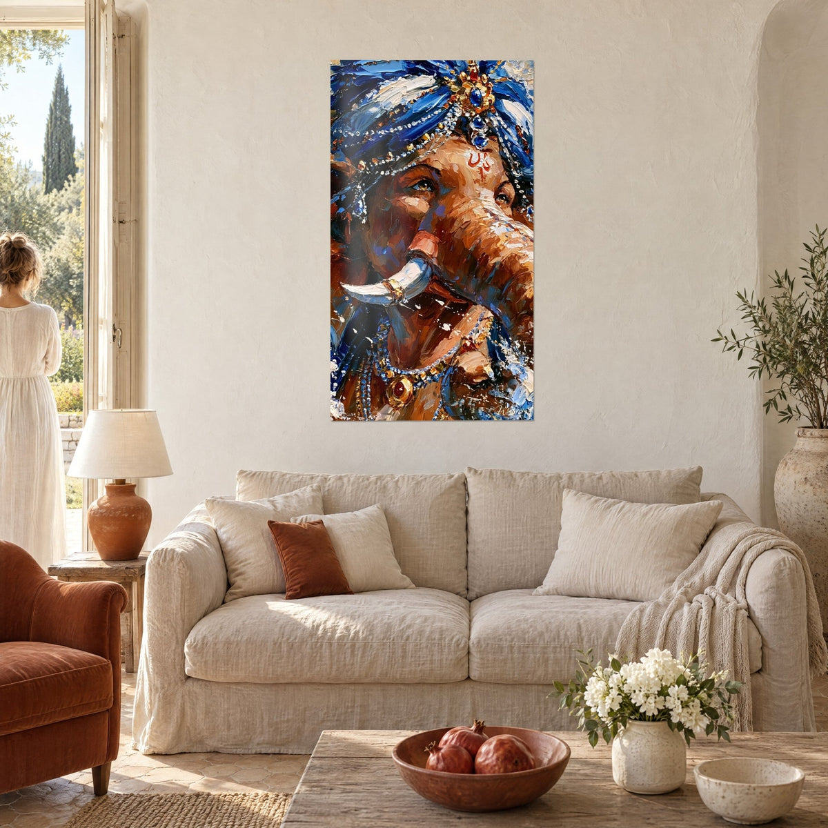 Wall art Ganesh with a blue turban set with gems, copper trunk and ivory tusk, above a sofa in a bright living room