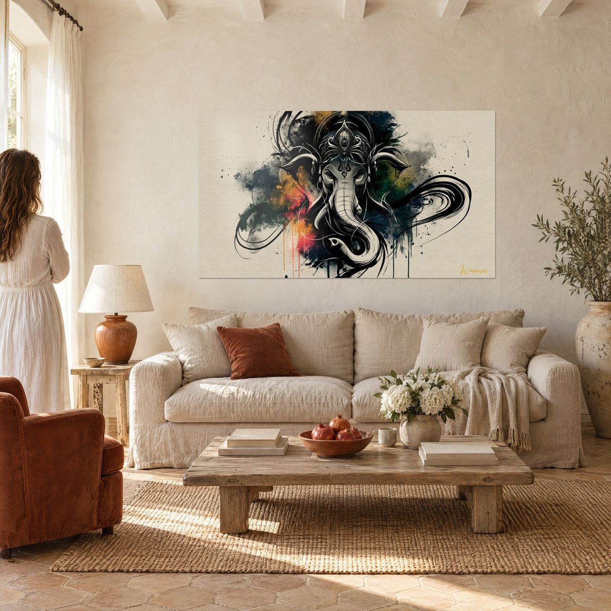 Wall art Ganesh elephant in black ink with red splashes, mustard yellow, hung above a sofa in a bright living room