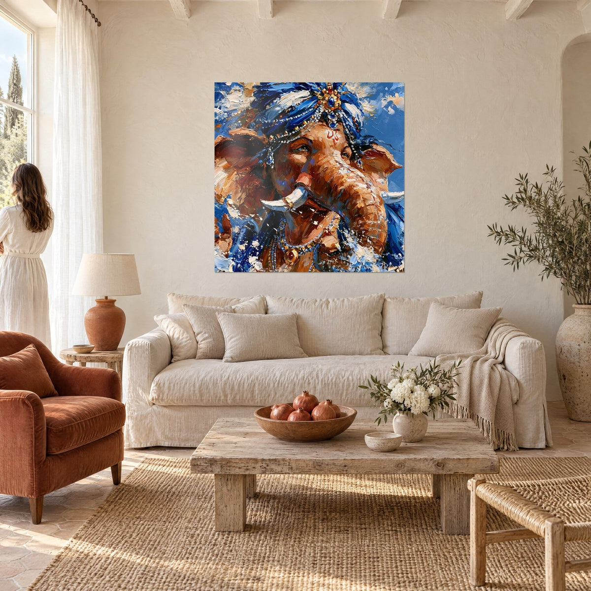 Tableau Ganesh en turban bleu serti de joyaux, défenses ivoire et pelage cuivré, au-dessus d'un canapé dans un salon lumineux