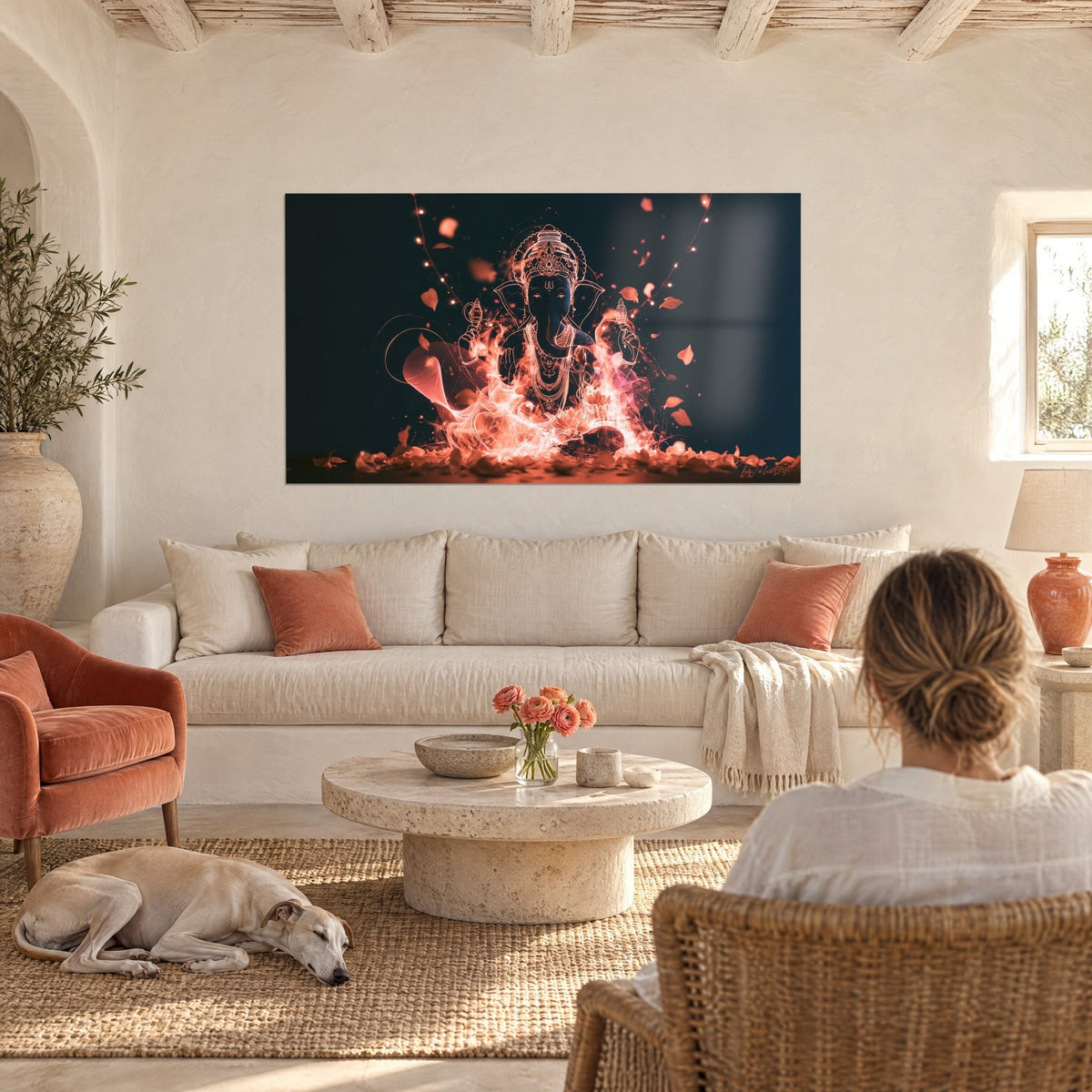 Wall art Ganesh in glowing lines on a midnight blue background, orange flames and petals, woman from behind and greyhound, above a sofa in a bright living room