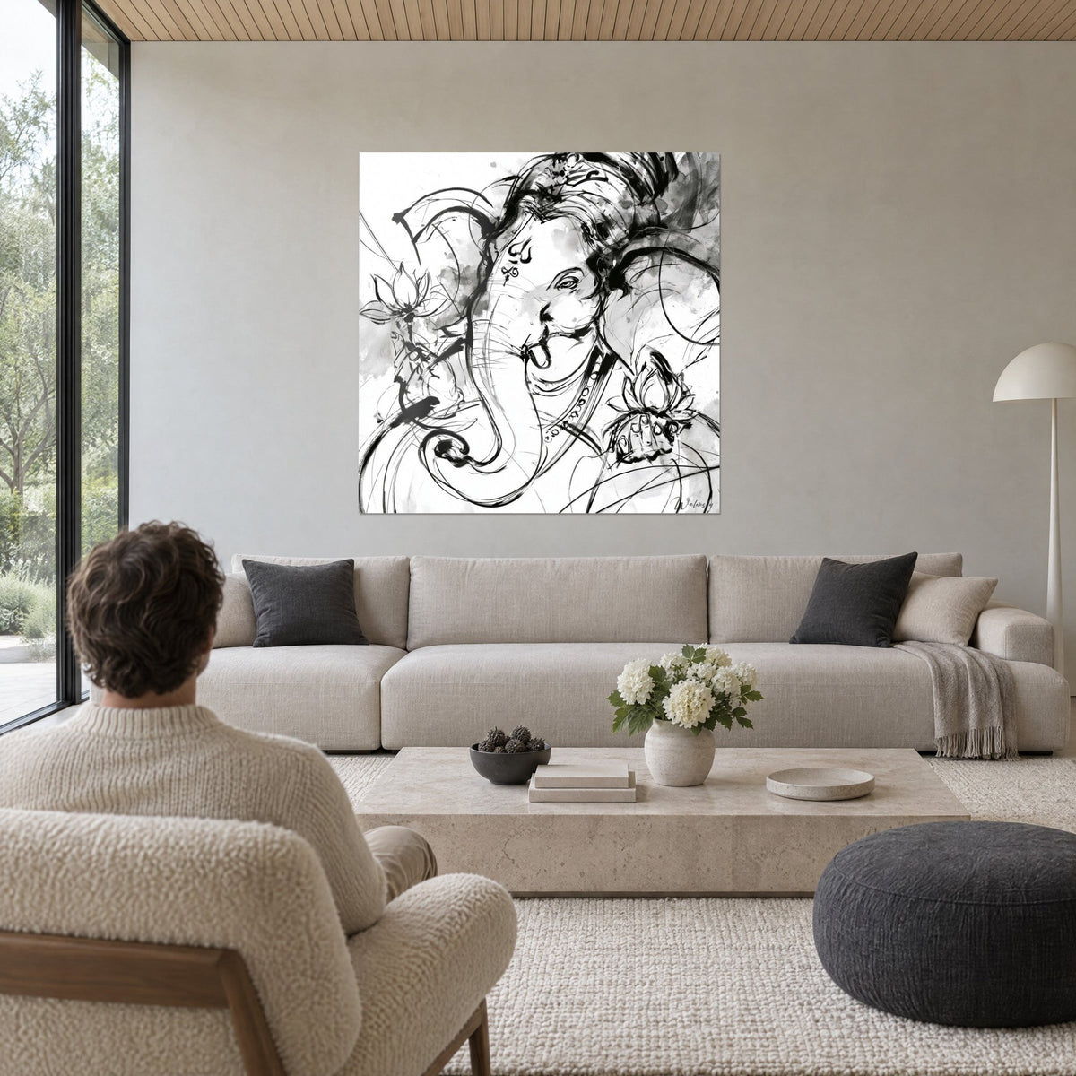 Gemälde Ganesha mit Elefantenkopf, schwarze Tuschezüge und grauer Lavierung, weiße Lotusblüten, über einem Sofa in einem hellen Wohnzimmer