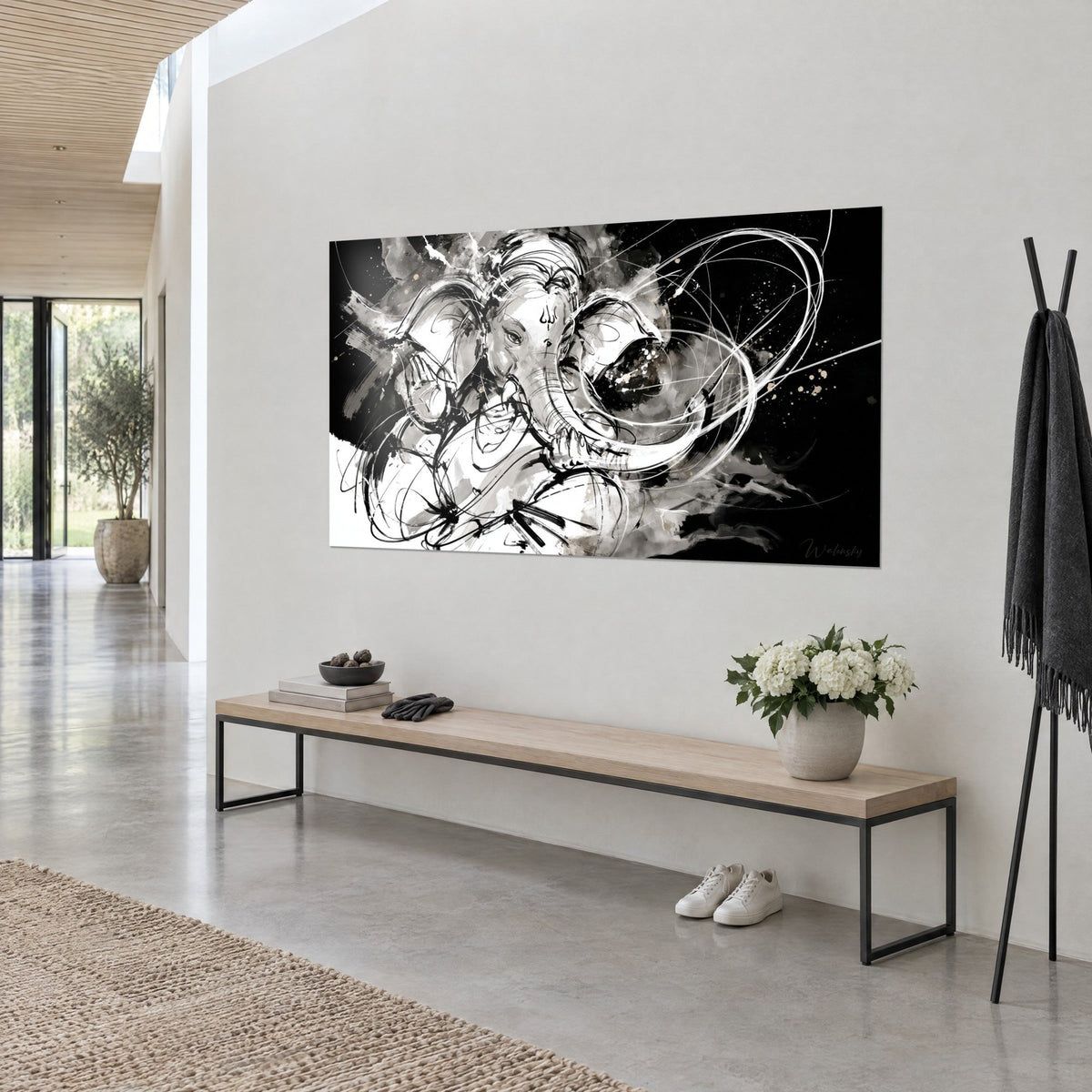 Tableau éléphant sacré aux volutes d'encre noire et grises sur fond sombre, en vue de trois-quarts sur un mur blanc, banc en bois