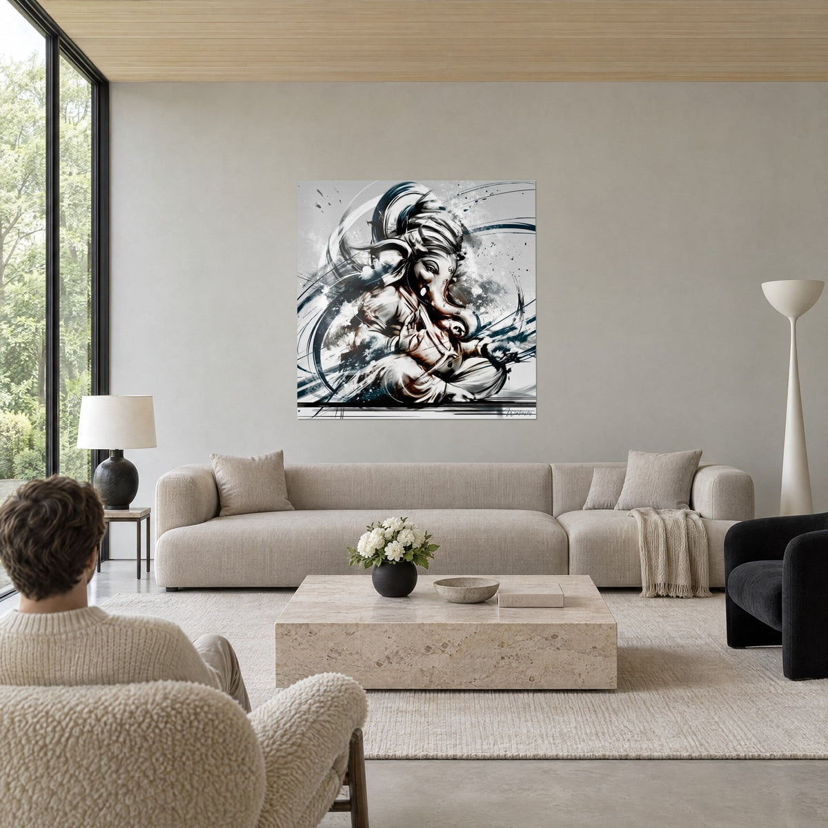 Tableau Ganesh à tête d'éléphant en coups de pinceau gris anthracite et blanc, éclaboussures bleu nuit, au-dessus d'un canapé dans un salon lumineux