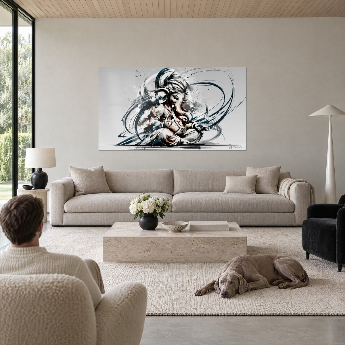 Wall art of a divine elephant in black and navy ink, swirling scrolls on a pearl grey background, above a sofa in a bright living room