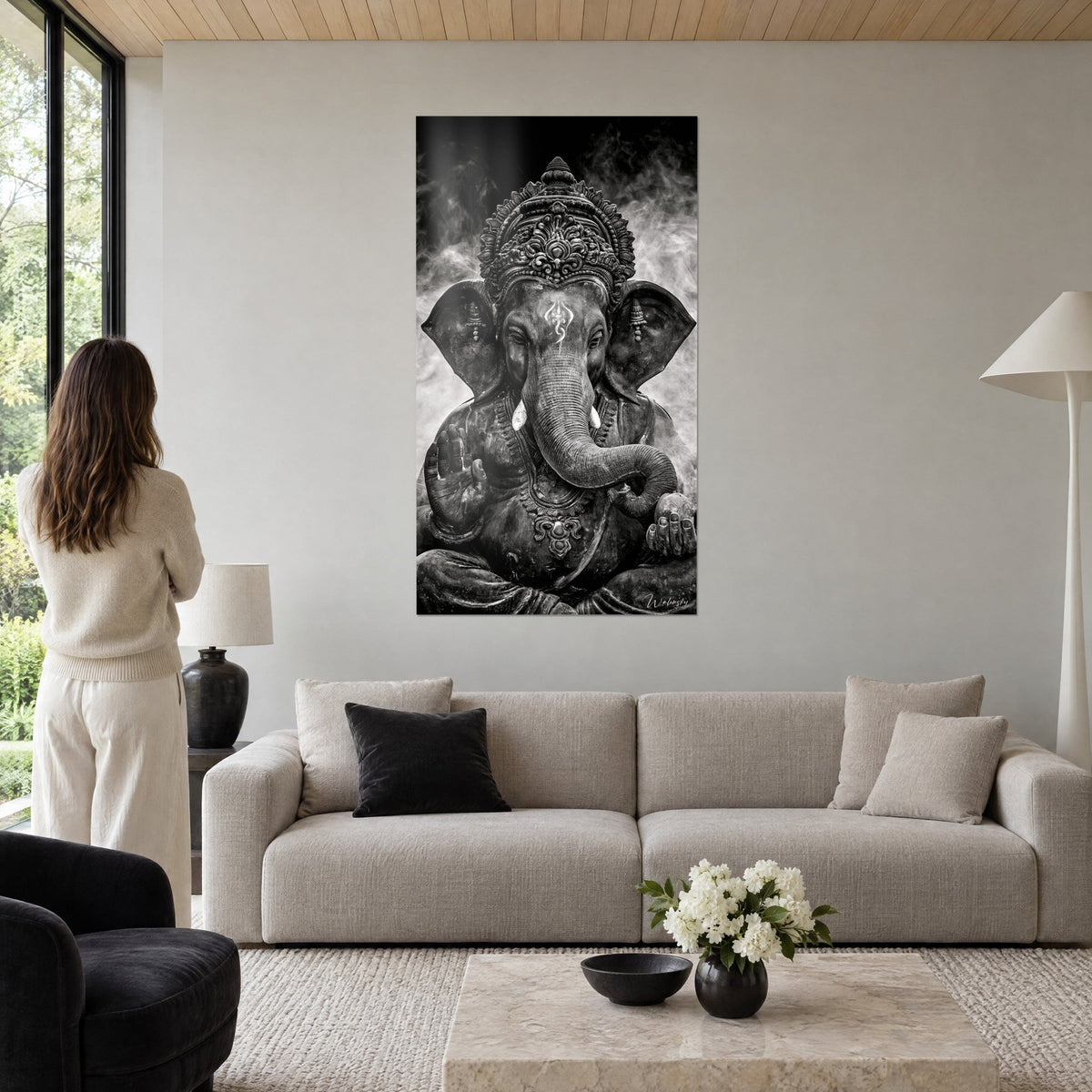 Tableau Ganesh en noir et blanc, trompe enroulée et tiare ciselée dans l'encens gris, au-dessus d'un canapé dans un salon lumineux
