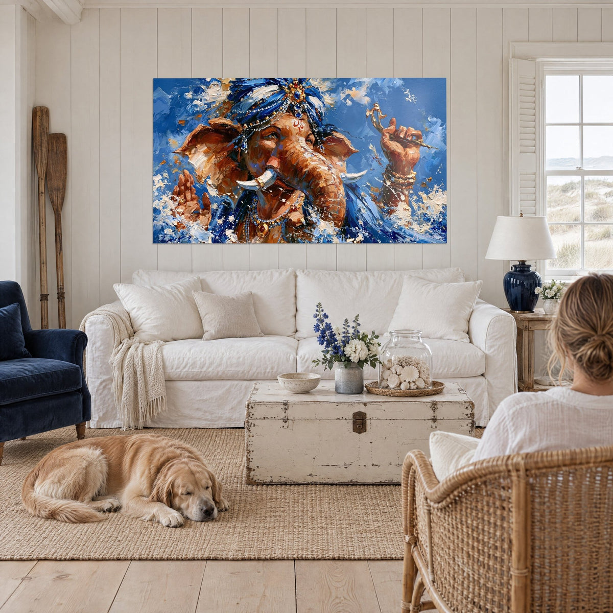 Wall art brown elephant with a pearl-studded blue turban, white splashes, above a sofa in a bright living room