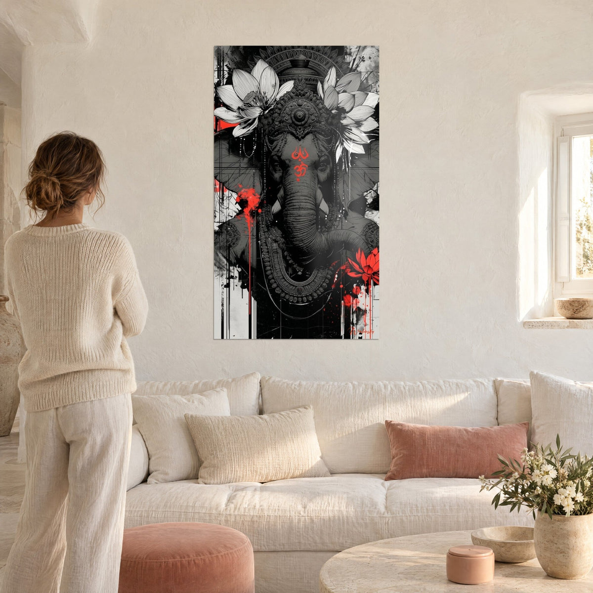 Wall art Ganesh, grey elephant adorned with white lotus flowers and a red om on the forehead, woman seen from behind, above a sofa in a bright living room