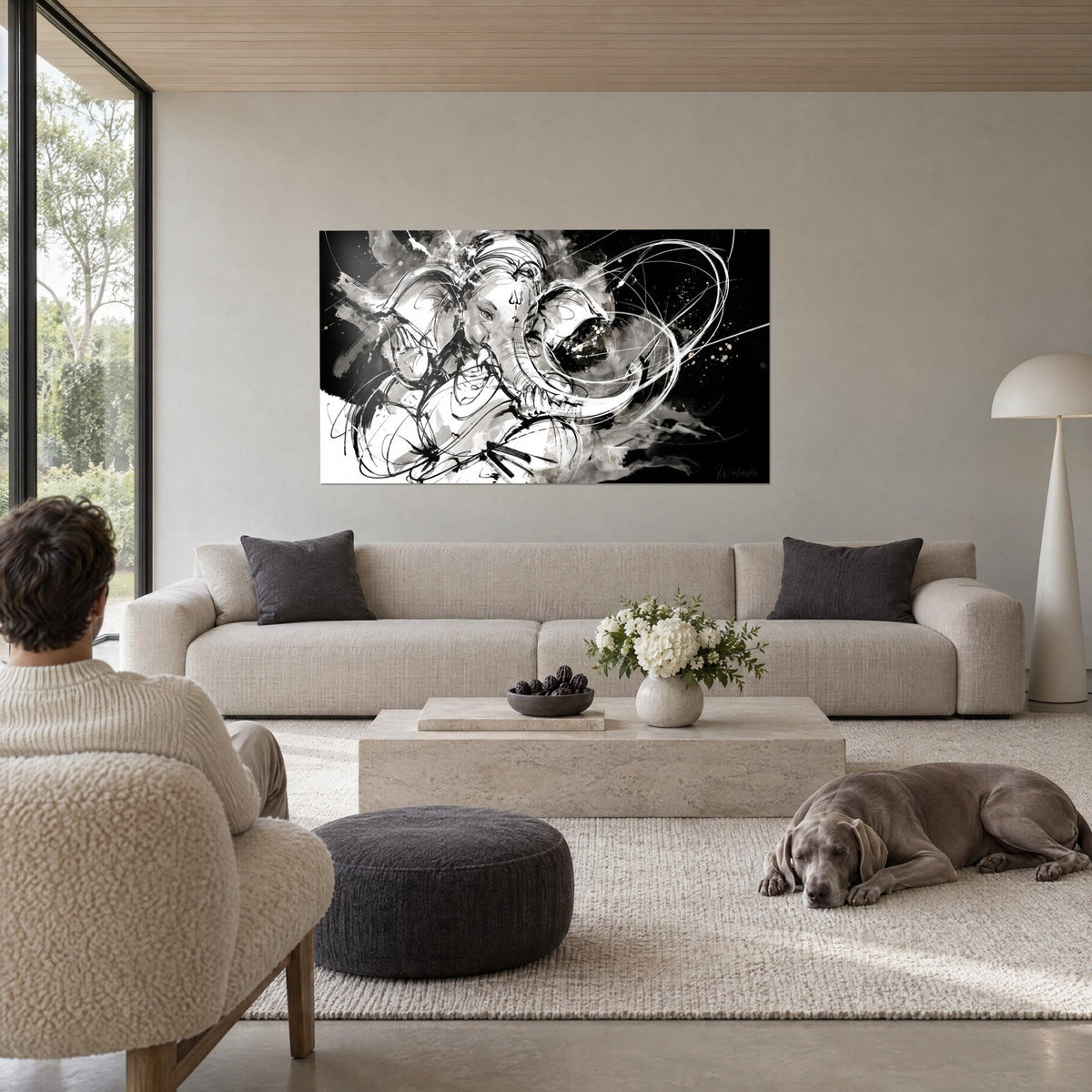 Tableau Ganesh à tête d'éléphant en traits d'encre noirs sur fond blanc, trompe enroulée, au-dessus d'un canapé dans un salon lumineux