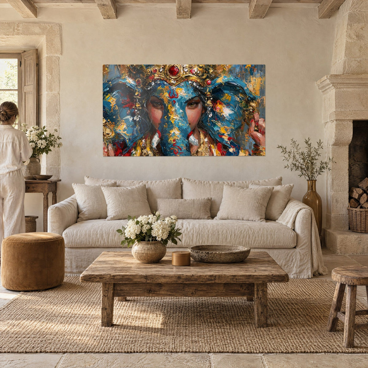 Wall art Ganesh with a blue face, golden crown and rubies, two people seen from behind, above a sofa in a bright living room