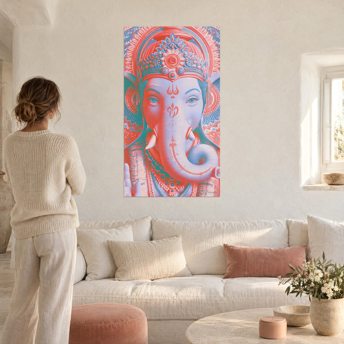 Wall art Ganesh in coral and pale blue tones, ornate crown and curled trunk, woman seen from behind, above a sofa in a bright living room