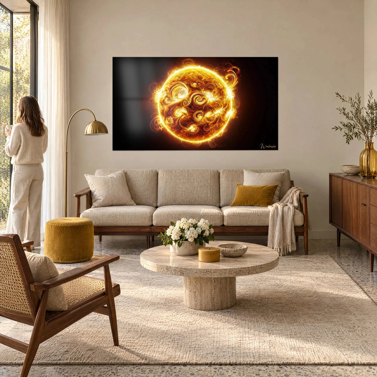 Tableau astre solaire en fusion, volutes d'or et d'ambre sur fond noir, femme de dos, au-dessus d'un canapé dans un salon lumineux